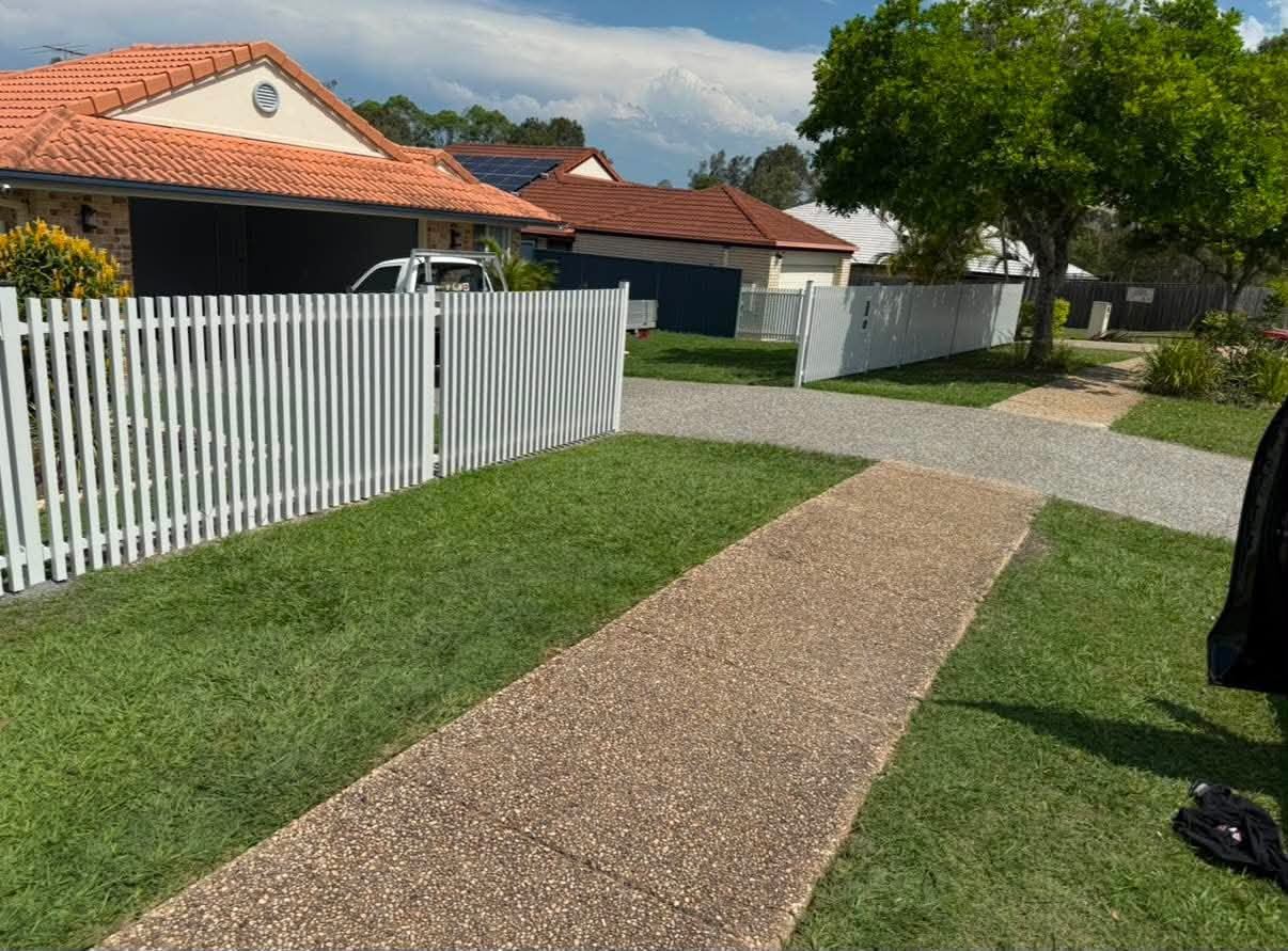 Timber deck beside a dark privacy screen and boundary fence