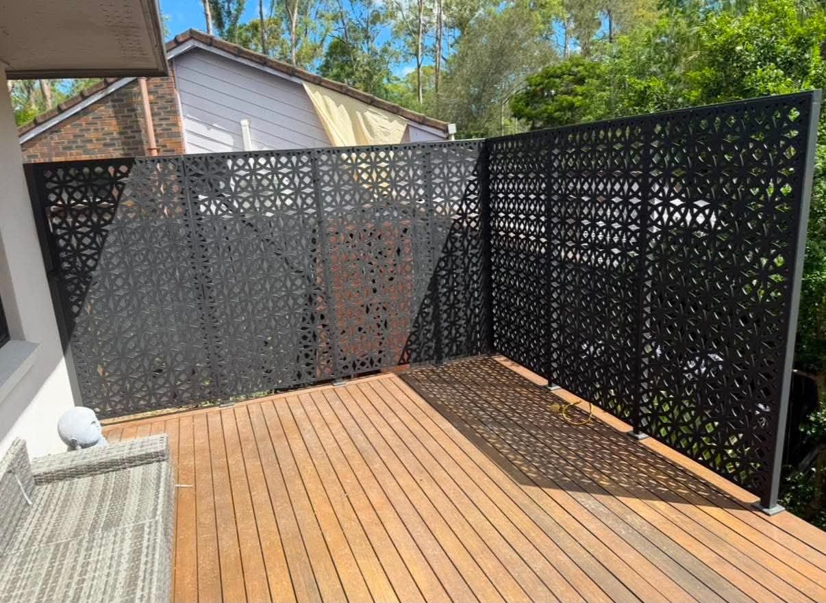 Completed composite garden deck with wide steps, hardwood posts and wire balustrade