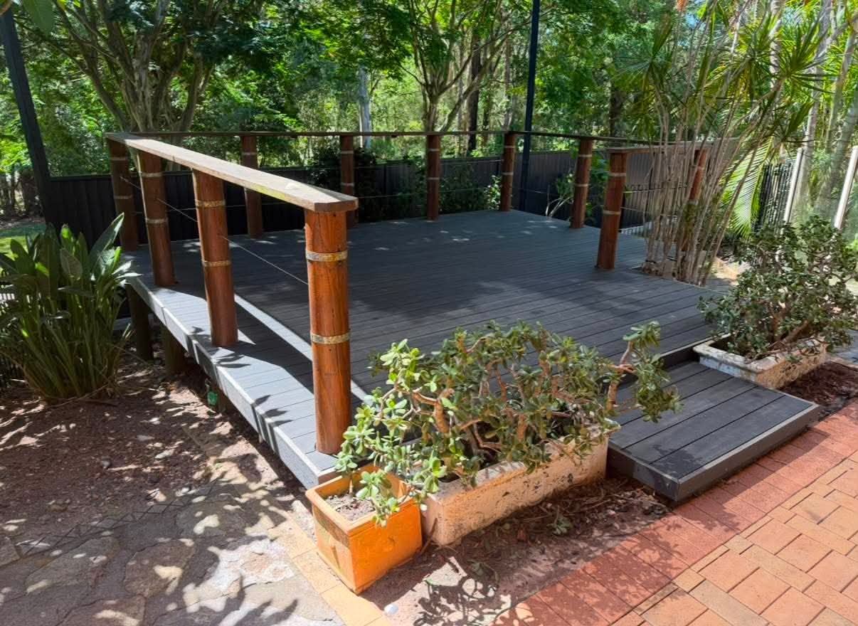 Angled view showing the deck steps, posts and surrounding established garden