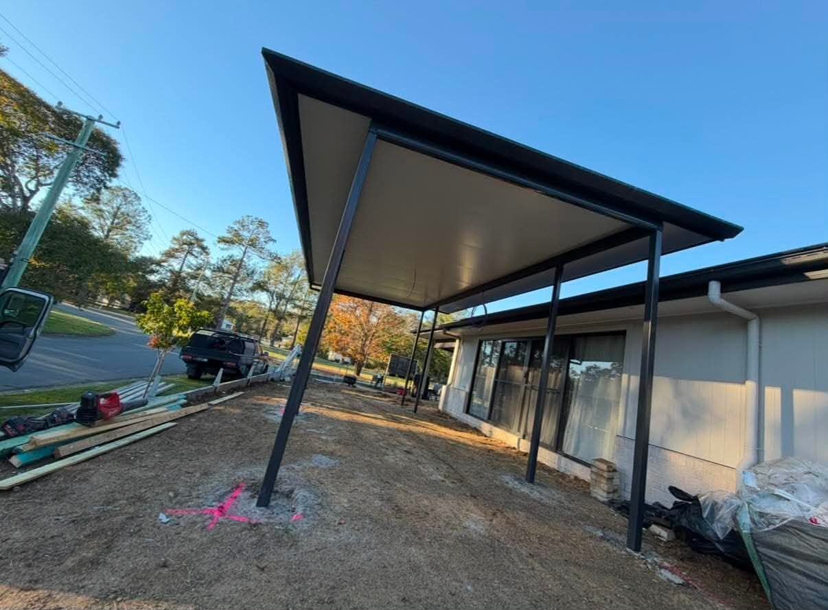 Angled view beneath the insulated patio roof across the backyard