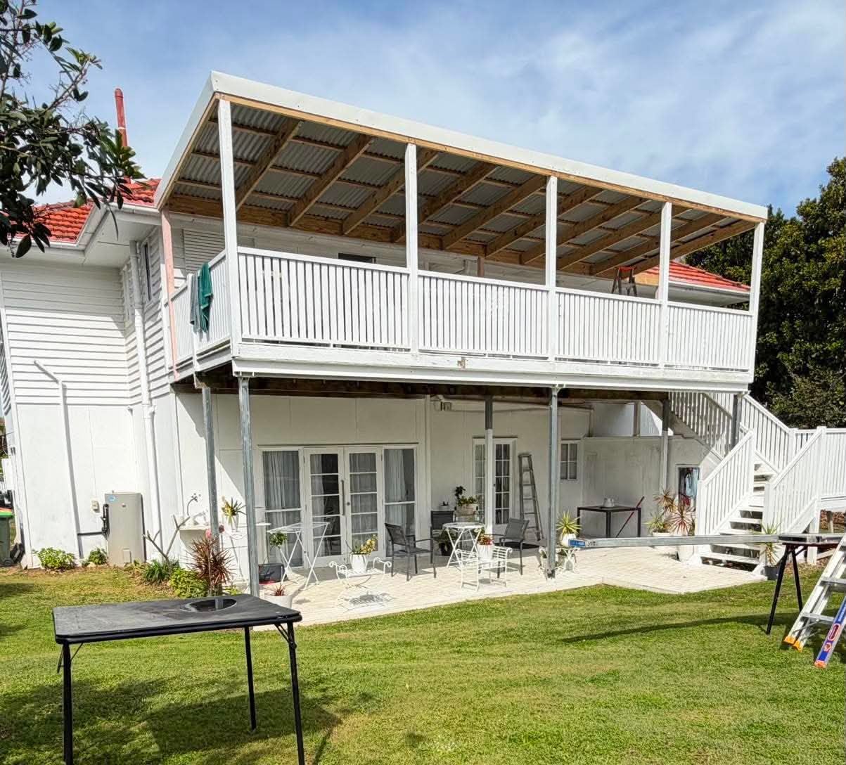 Two-storey Queenslander with upper deck roof structure and external stairs