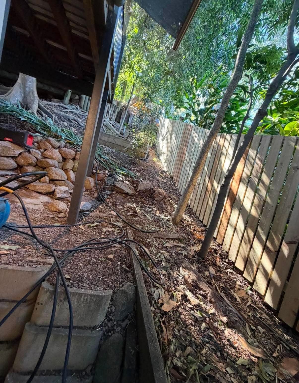 Narrow-access inspection area beside a garden shed before repair work