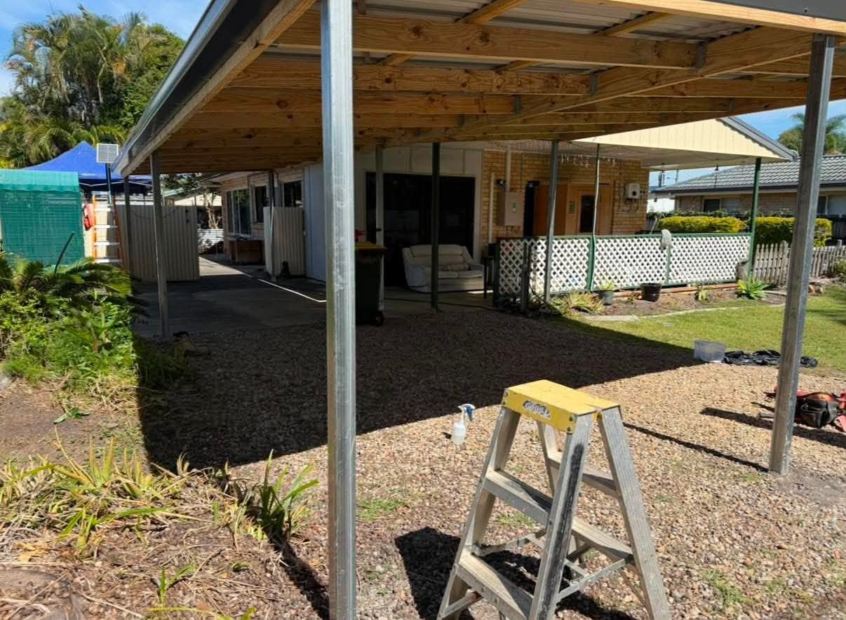 Wide interior view showing rafters and posts during the carport build