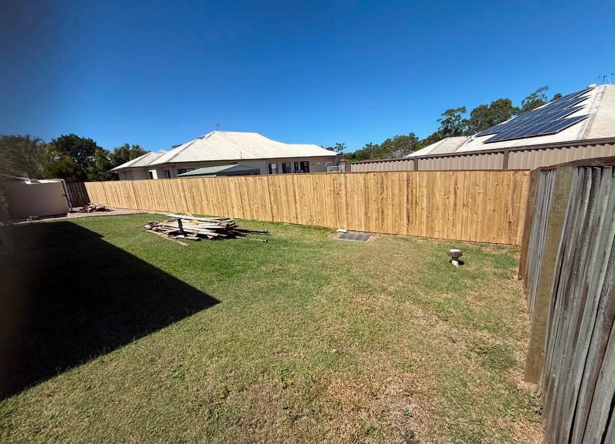 New timber post and rail boundary fence running along the rear of a large grassed yard